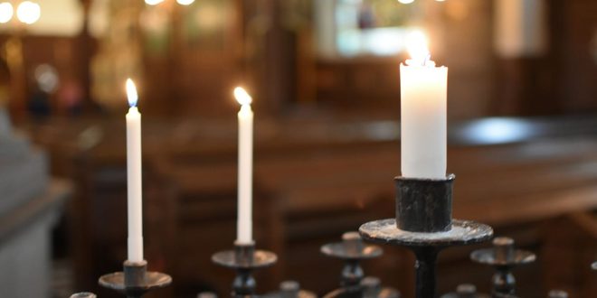 vela acesa sobre altar em igreja católica