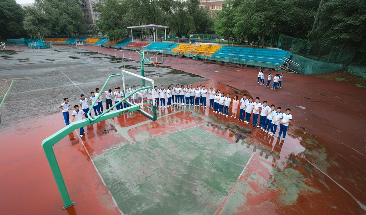Professor de educação física orienta alunos durante aula em quadra esportiva