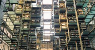 livros abertos empilhados sobre mesa de biblioteca com luz natural
