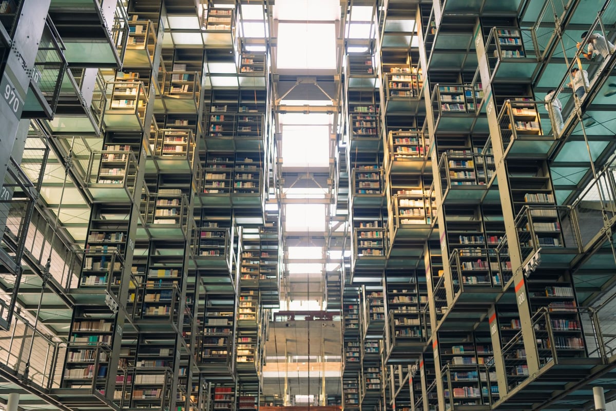 livros abertos empilhados sobre mesa de biblioteca com luz natural