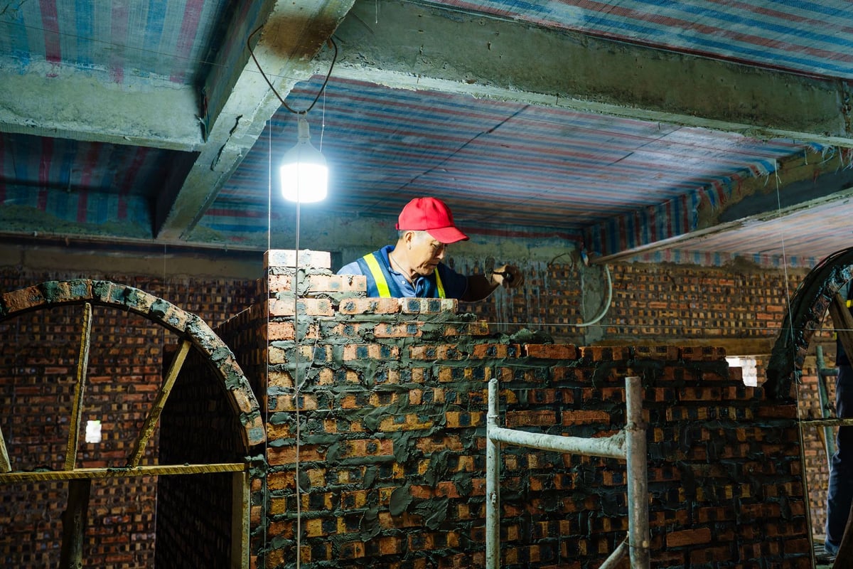 pedreiro assentando tijolos em parede de obra de construção civil