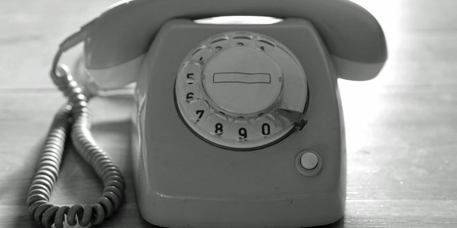 Secretária organizando documentos e atendendo ao telefone em um escritório