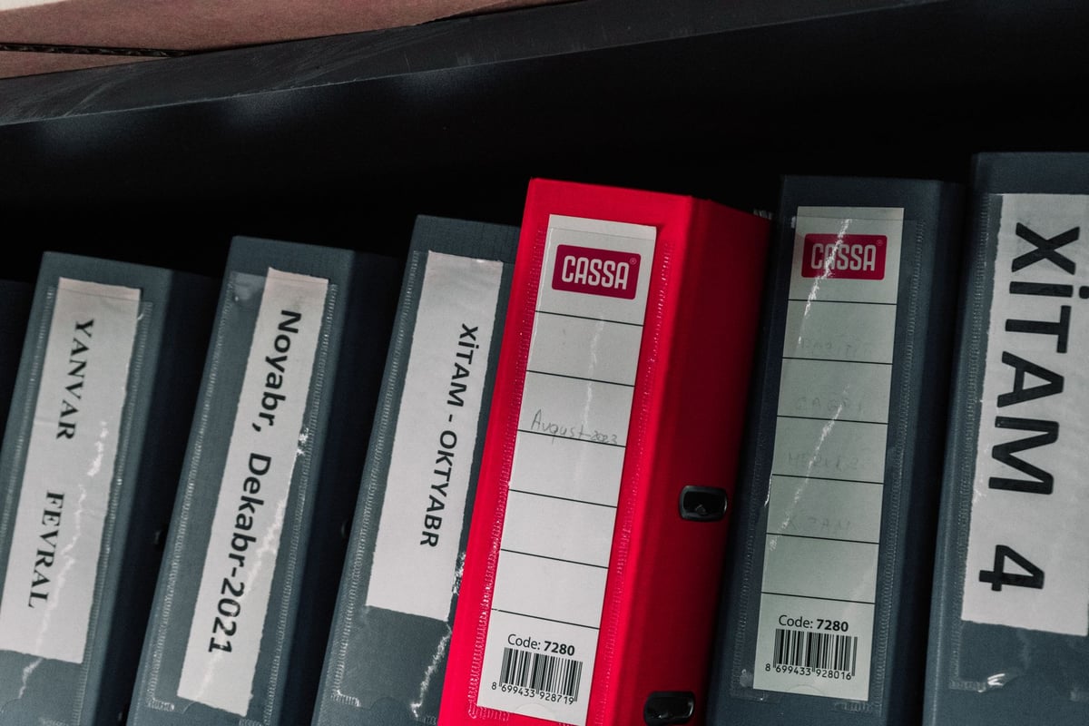 Arquivos e pastas de documentos organizados em estante de escritório
