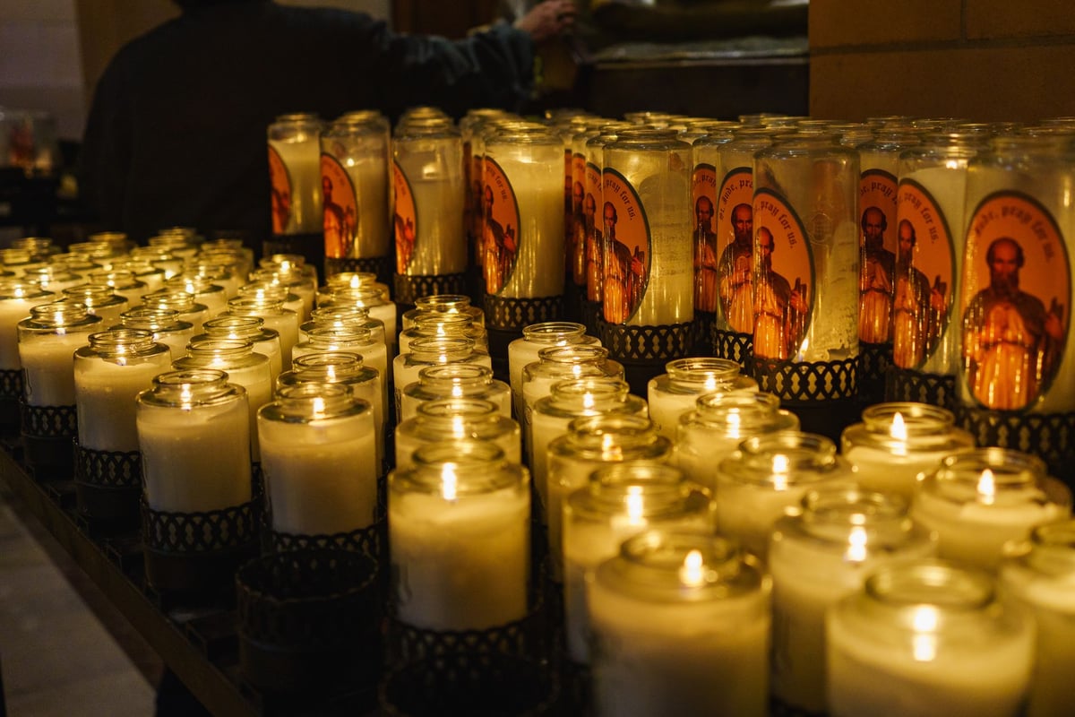 imagem de Nossa Senhora das Mercês em altar de igreja católica cercada de velas