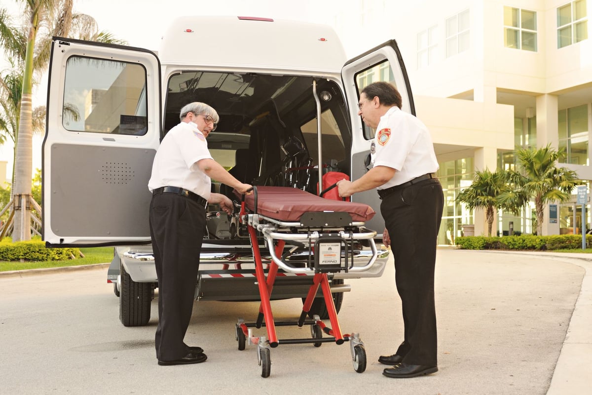Fachada de hospital com ambulância estacionada na entrada principal