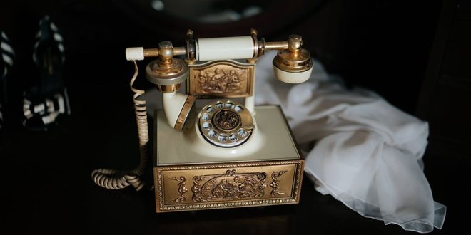 Telefone antigo de linha fixa sobre mesa de madeira no Dia do Telefone