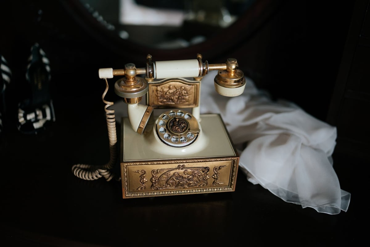 Telefone antigo de linha fixa sobre mesa de madeira no Dia do Telefone