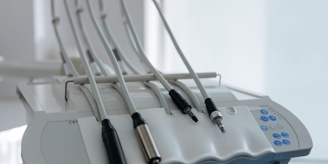 mãos de profissional de saúde segurando a mão de paciente em leito hospitalar