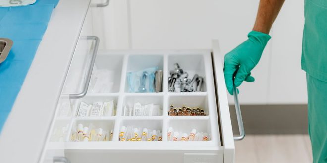 Médico usando estetoscópio para examinar o coração de um paciente em consultório