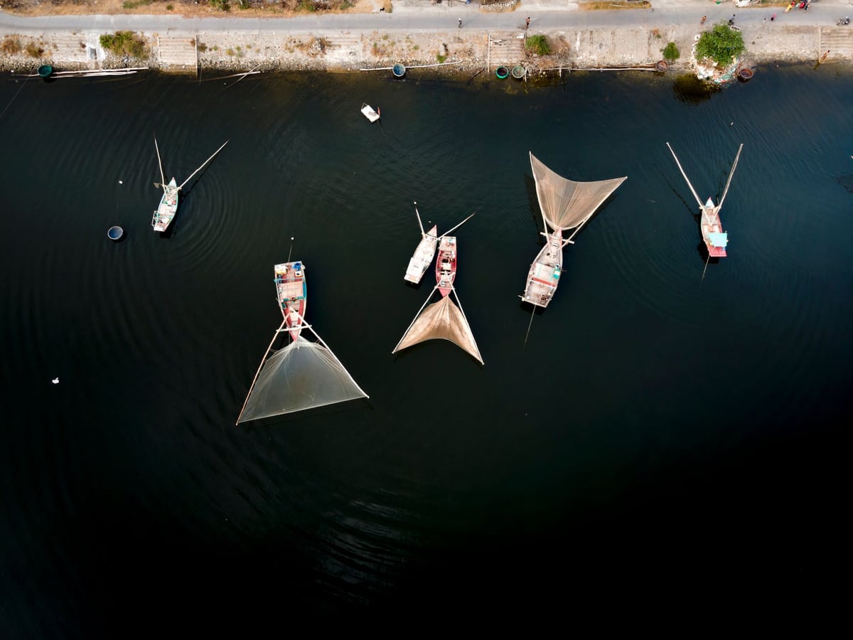 Casario colonial antigo à beira-mar, com barcos de pesca sobre a areia