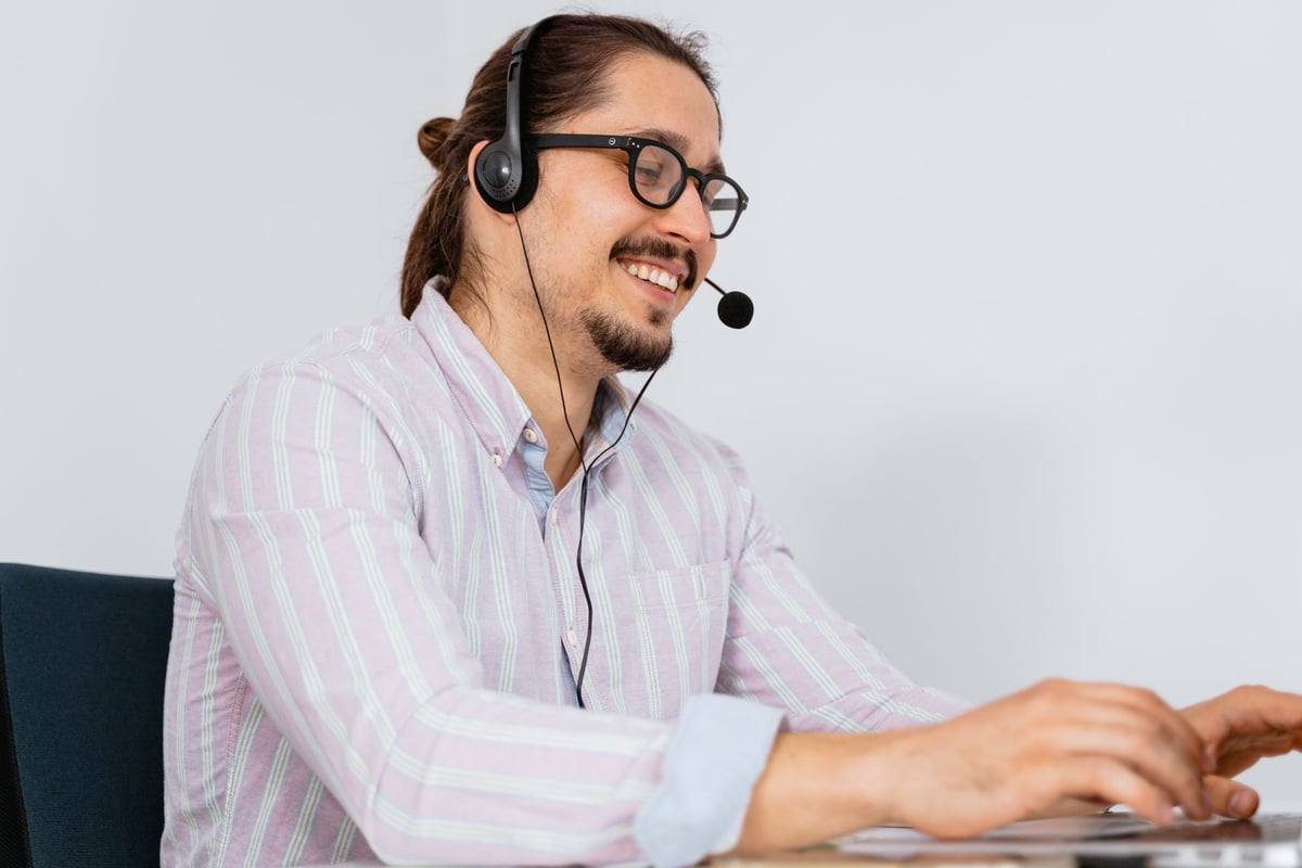 Operador de telemarketing atendendo clientes com fone de ouvido em central de atendimento