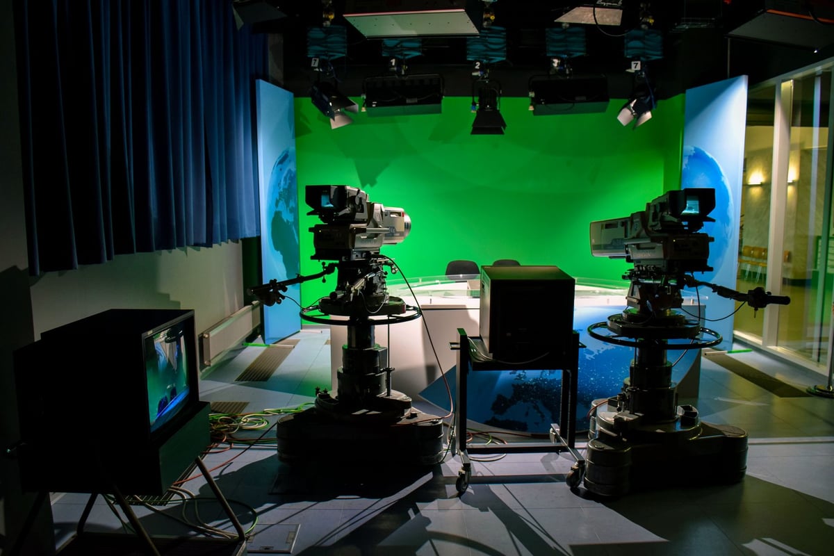 Estúdio de televisão com câmeras apontadas para apresentador no ar