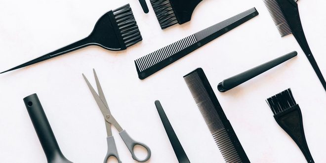 Instrumentos de cabeleireiro, barbeiro e manicure organizados sobre uma bancada de salão de beleza