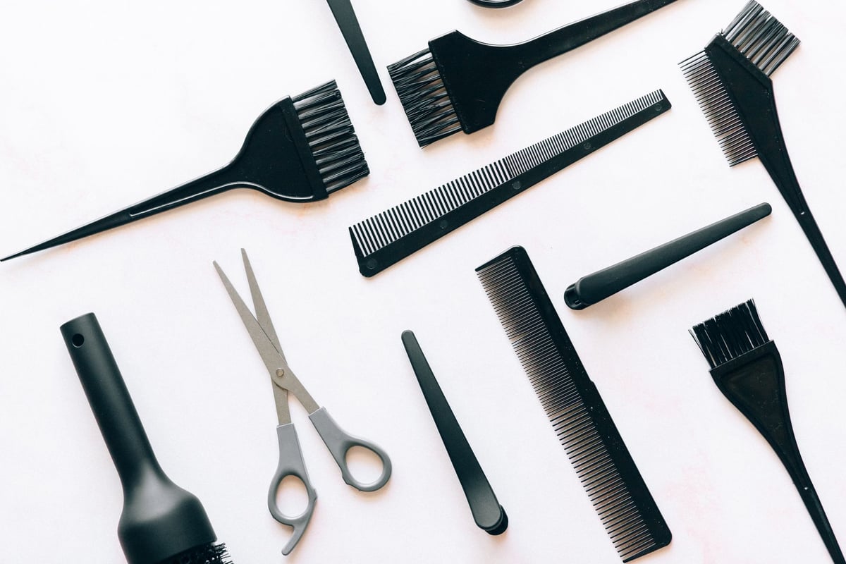 Instrumentos de cabeleireiro, barbeiro e manicure organizados sobre uma bancada de salão de beleza