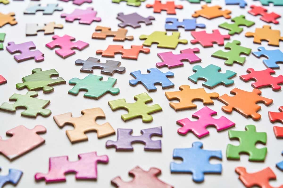 Quebra-cabeça colorido em mesa, símbolo comum de conscientização sobre espectro autista