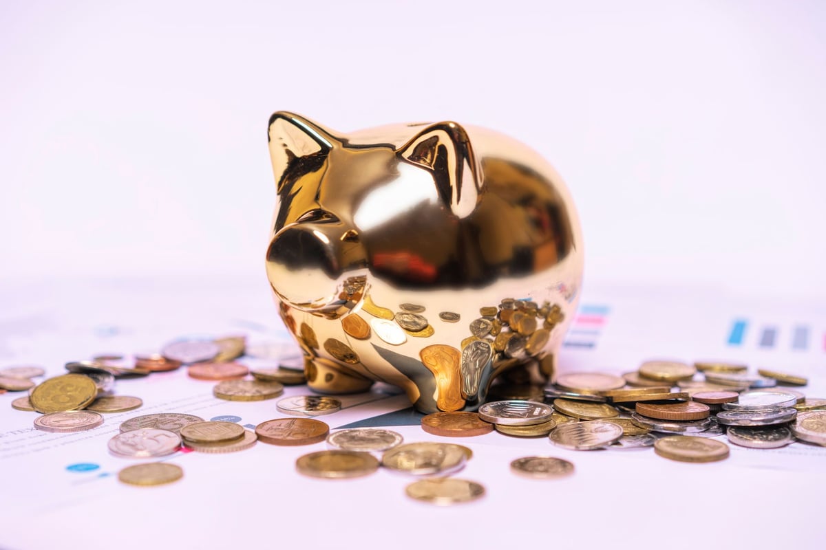 cofrinho de porco com moedas ao lado de notas de dinheiro