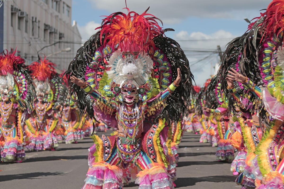 Barracão de escola de samba com fantasias coloridas penduradas