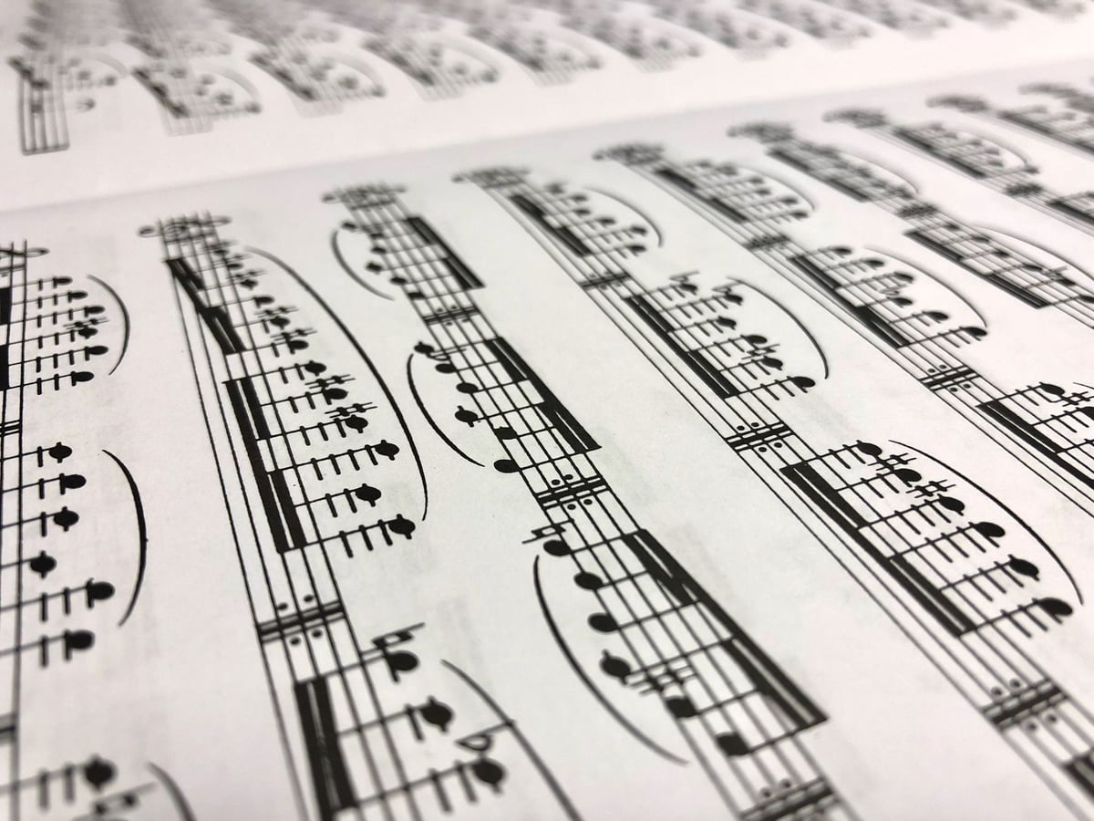 Partitura antiga aberta sobre um piano de cauda em um teatro vazio