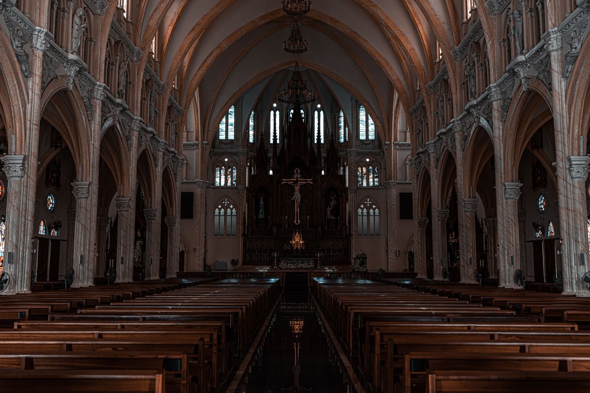 Bíblia antiga aberta sobre um púlpito de madeira em igreja iluminada por luz natural
