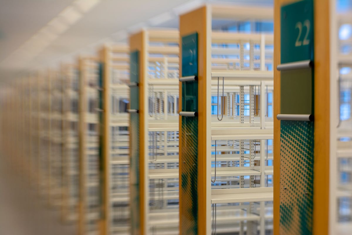 Escrivaninha de madeira com máquina de escrever e pilha de livros