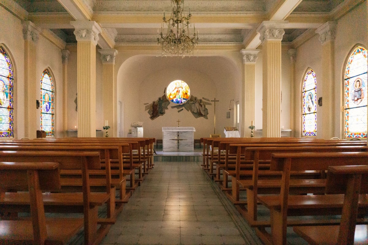 bengala branca apoiada em banco de madeira de igreja vazia