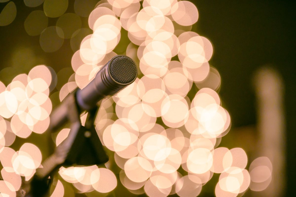microfone de pé iluminado sobre um palco vazio de teatro