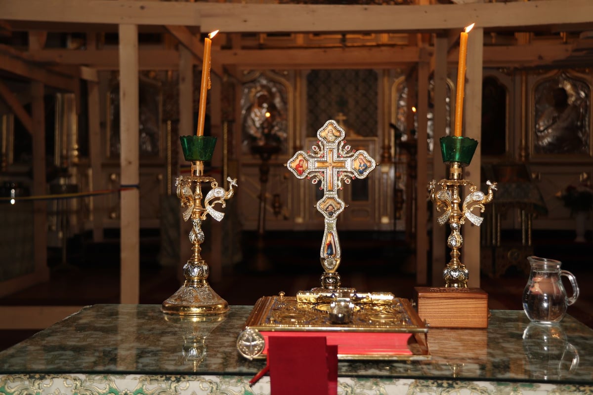 Coroa do Advento com quatro velas acesas sobre mesa decorada