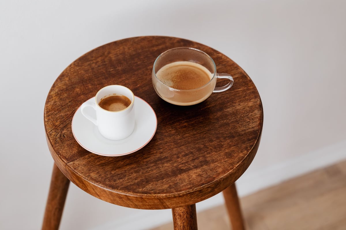Duas xícaras de café fumegante sobre mesa de madeira em encontro entre amigos