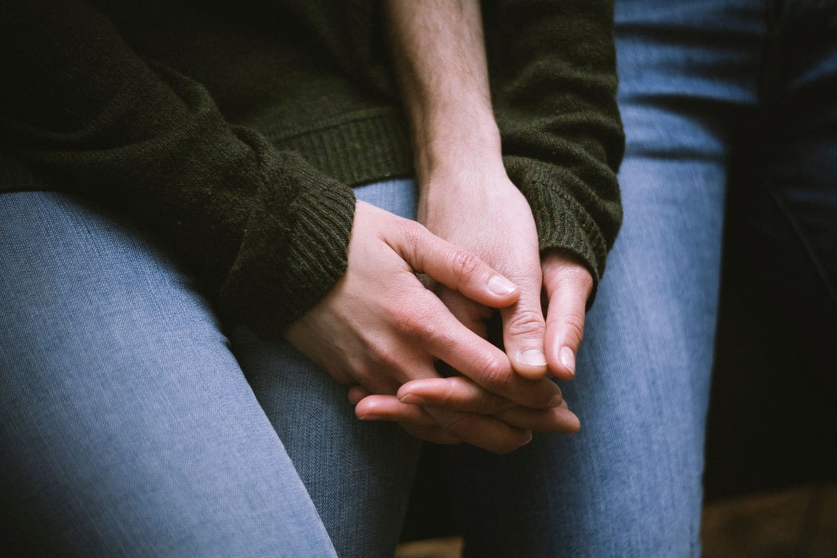 Mãos calejadas segurando um punhado de grãos colhidos em uma plantação