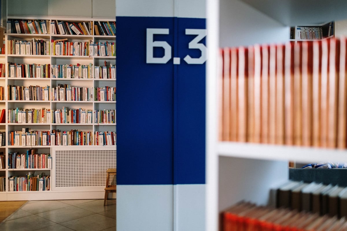 Pilha de livros de capa dura antigos sobre mesa de madeira em biblioteca
