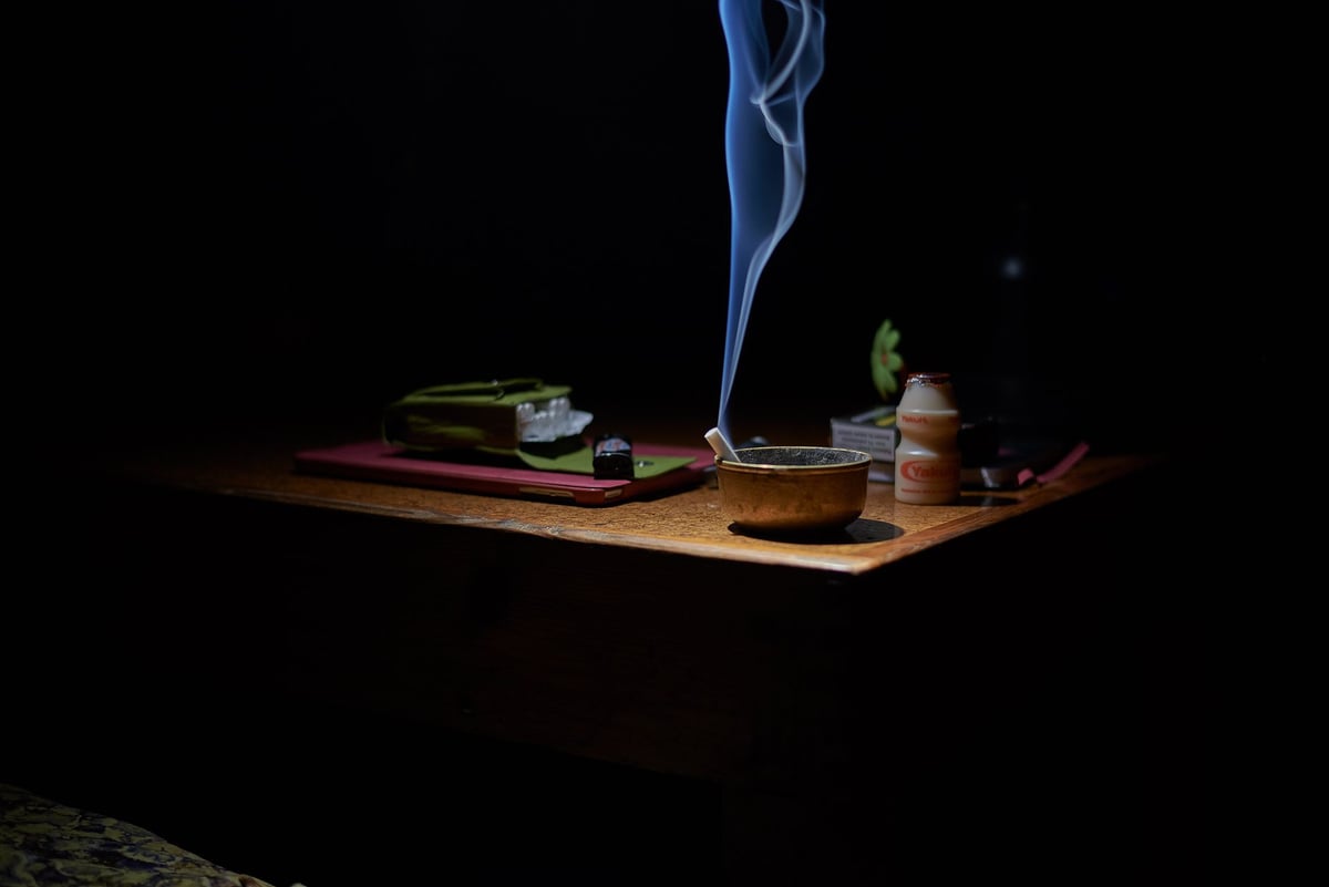 Cinzeiro vazio ao lado de maço de cigarros fechado sobre mesa
