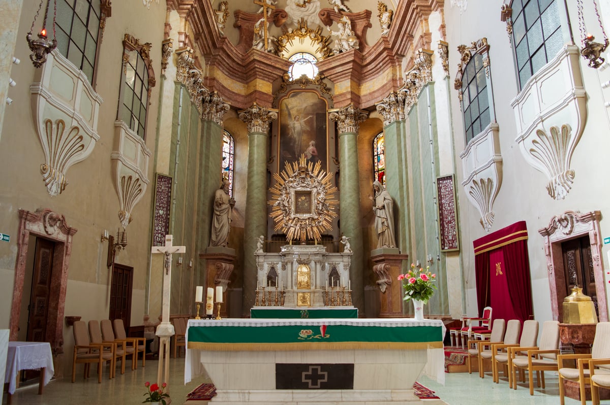 Vaso com rosas ao lado de uma pequena imagem de freira em nicho de altar doméstico