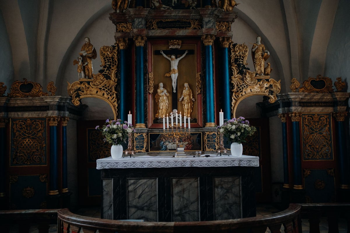 Vela acesa diante de um crucifixo em uma cela simples de oração
