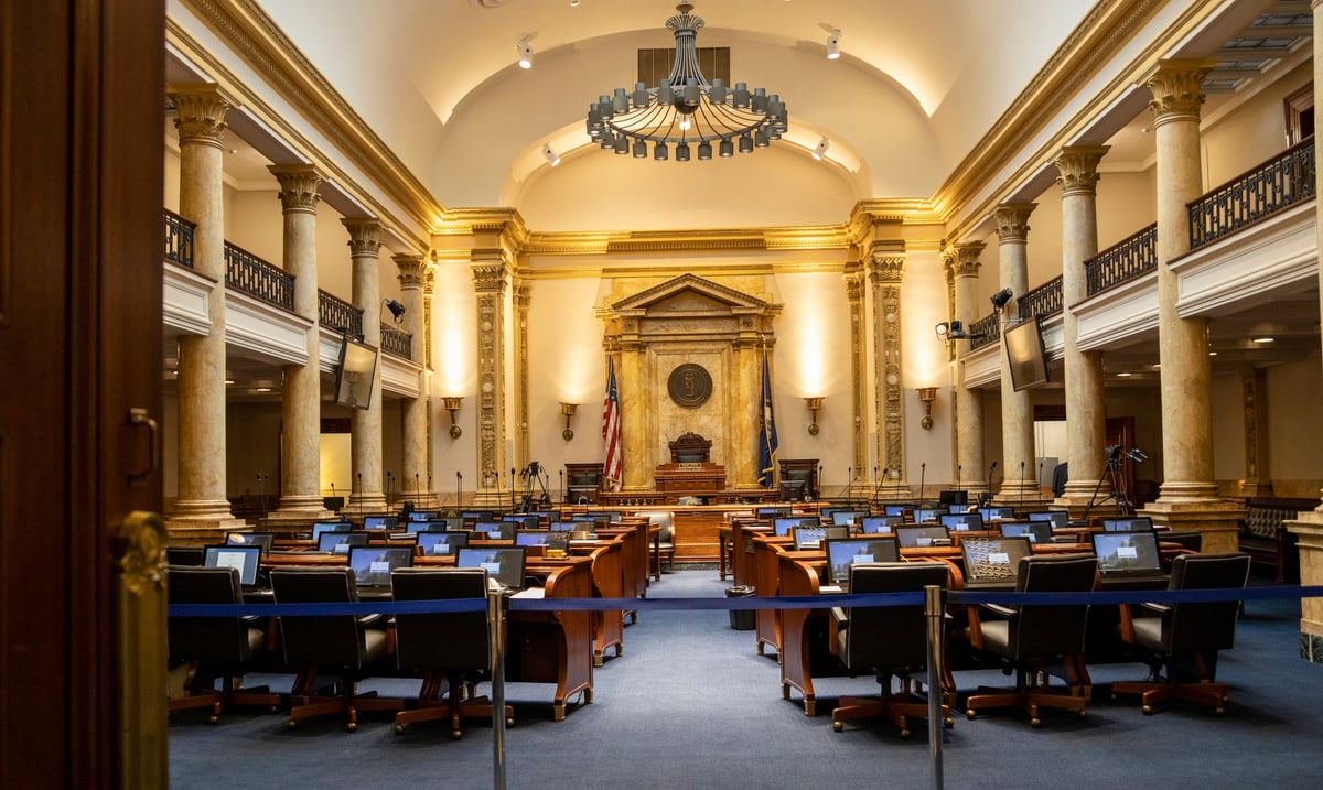 Livro de atas aberto sobre mesa em sala de sessões legislativas